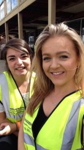 Two people posing wearing high visibility vest.