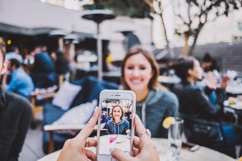 Someone taking a photo of someone using a phone