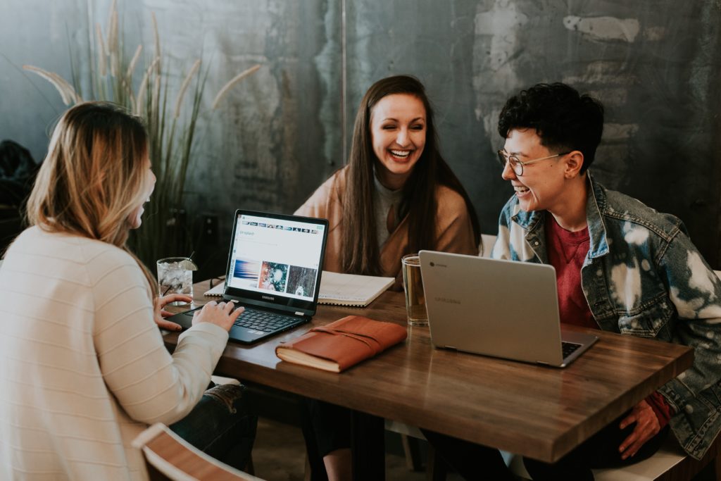 Three interns sitting at a desk talking