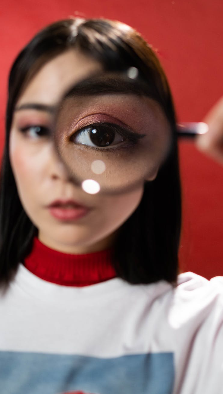 a woman holding a magnifying glass to her eye