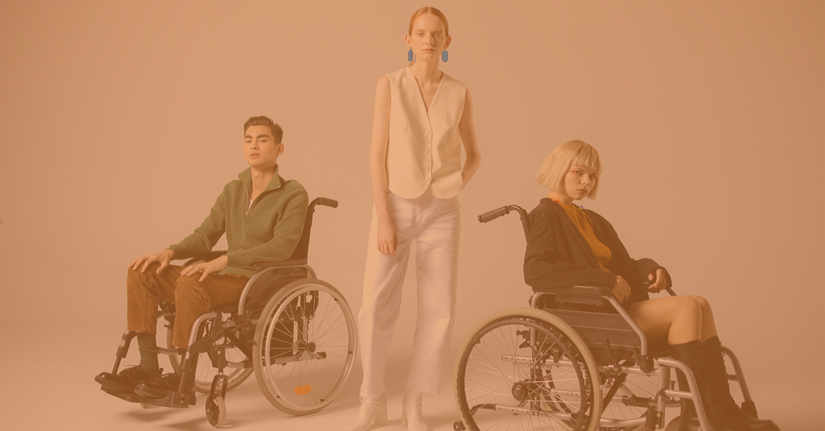 a white woman and asian man in a wheelchair, with another woman stood next to them in the middle
