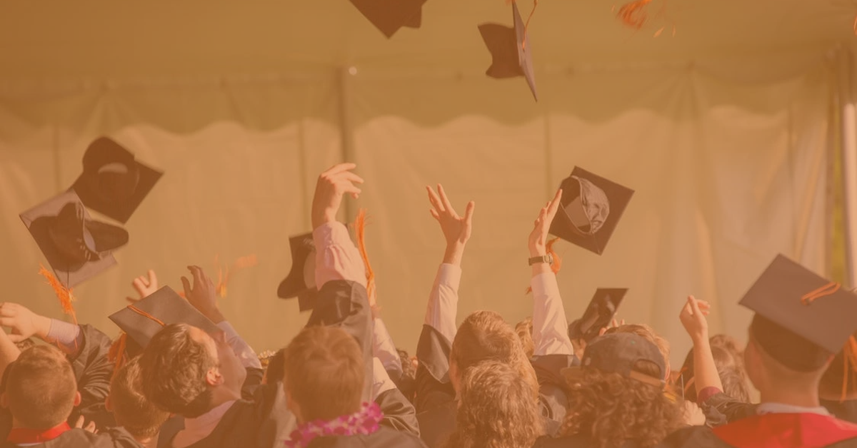 graduating students thrwing hats in the air