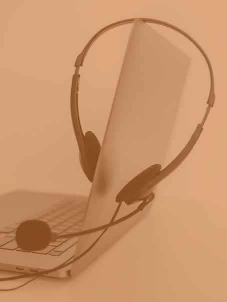 a laptop with a headset sat on top