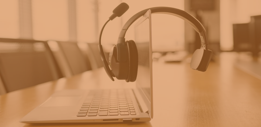 Website design for the visually impaired - A headset laying on top of a laptop in an office setting