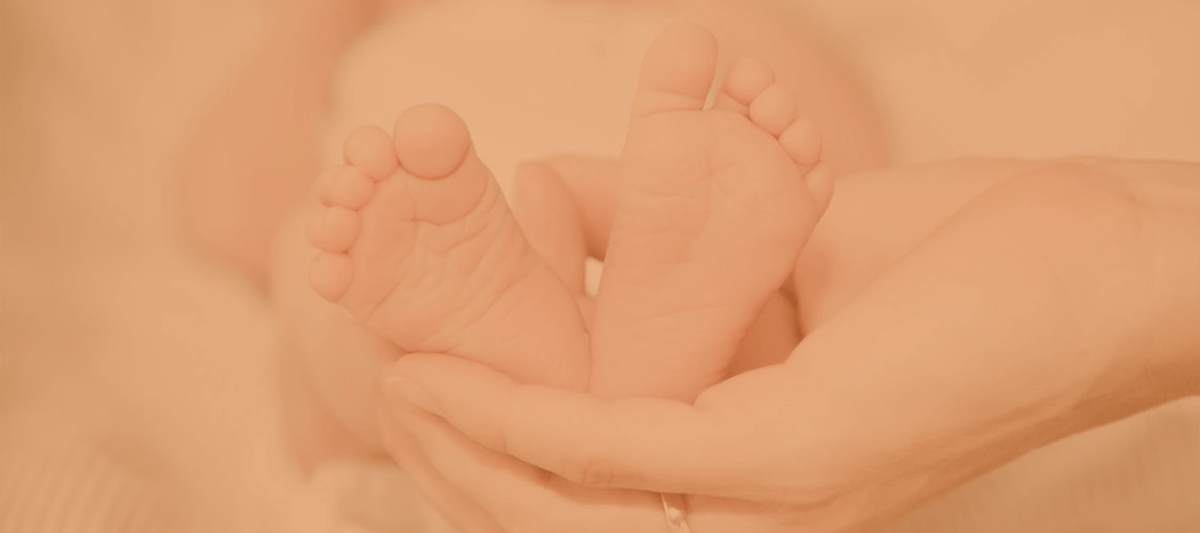 baby feet being held by a parents hands