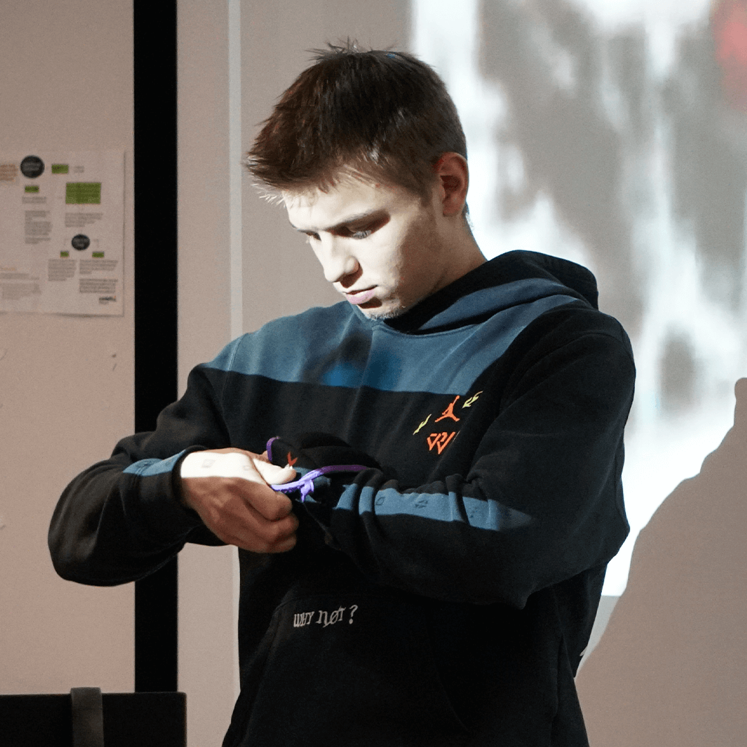 A student is putting on weights around his wrist