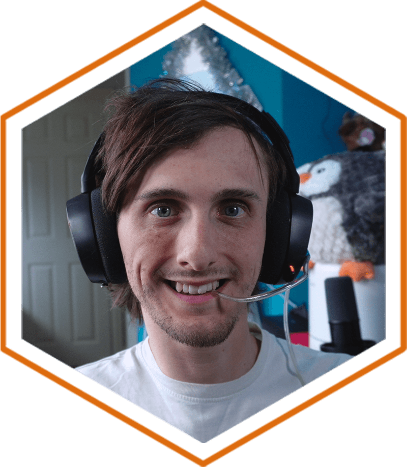 Alex Walls sat in his bedroom smiling, whilst wearing a gaming headset, with a microphone in the background to record his streaming session