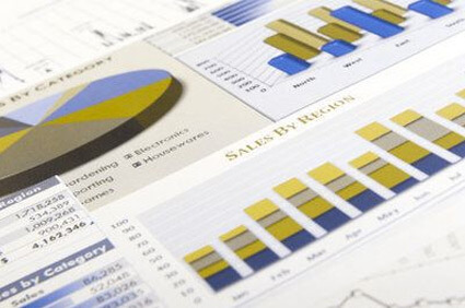 a piece of paper which has an array of pie charts and bar charts across it, showing how someone with deuteranopia would view these graphs, which changes the colours to more yellow, brown and blue shades.